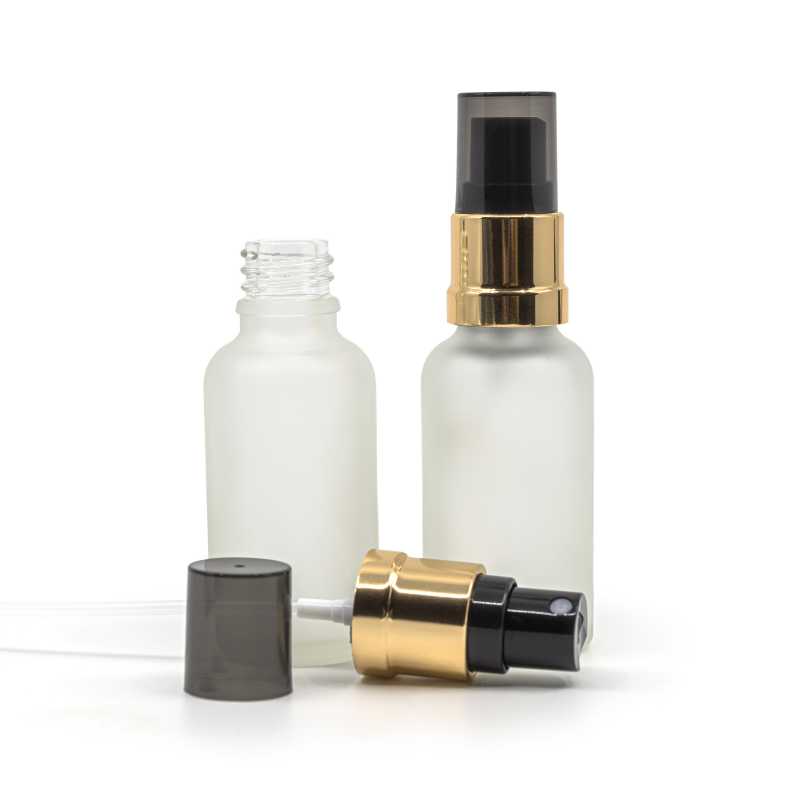 Átlátszó matt üvegpalack, fekete permetezőfúvóka fényes arany gallérral, füstszínű kupak, 30 ml